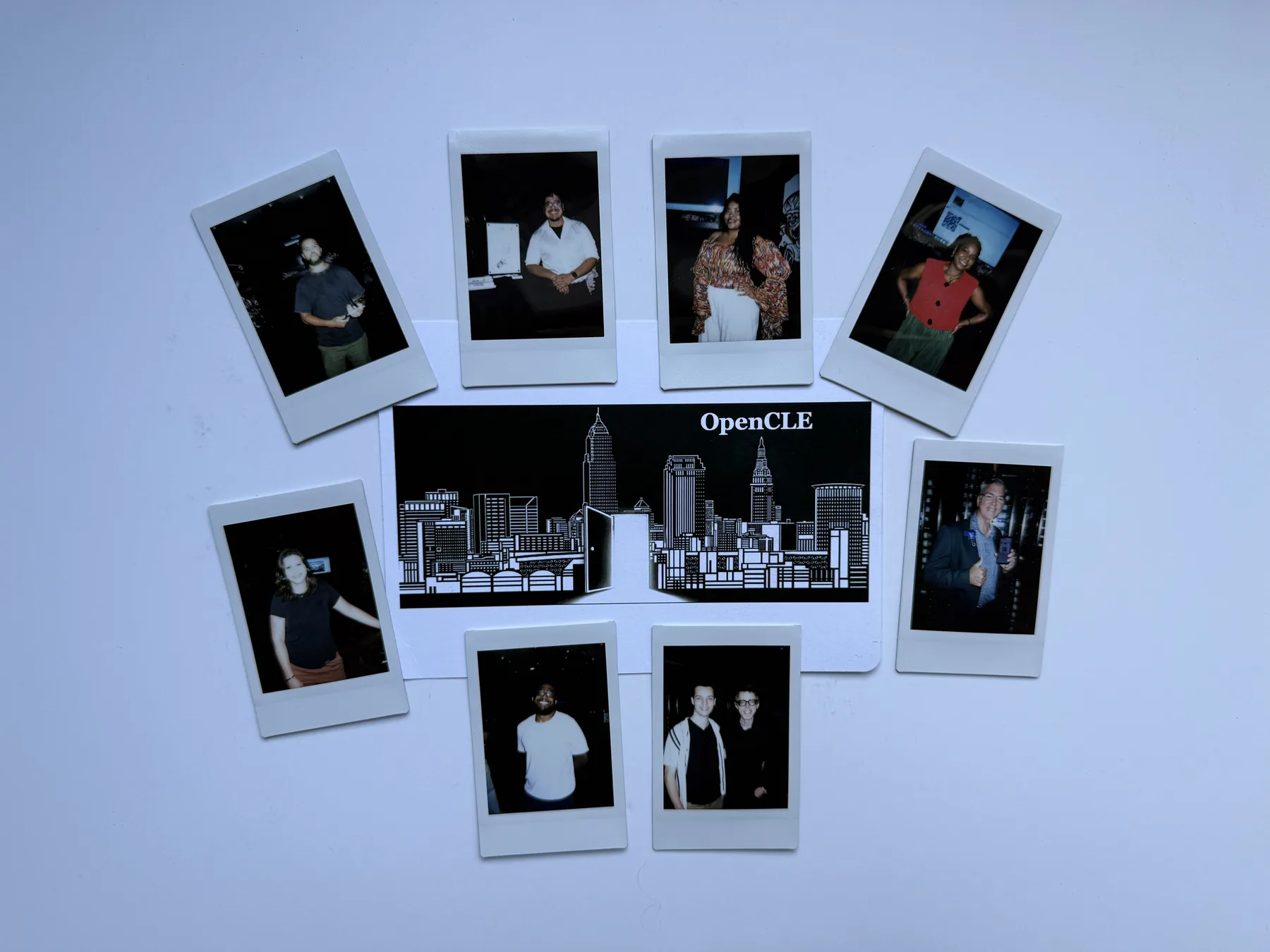 Instant portraits arranged around an OpenCLE cityscape card after the gathering