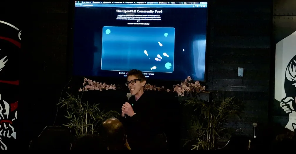 A presenter standing before the OpenCLE community display